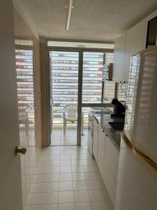a kitchen with a door leading to a balcony with a view at Torre Marina II Punta del Este in Punta del Este