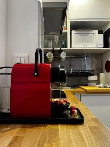 Una cafetera roja sentada en una barra en la cocina en TOUR EIFFEL-MONTPARNASSE JOLI STUDIO, en París