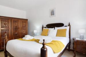 um quarto com uma cama com um cobertor amarelo em Casa do tio Inácio em Santana