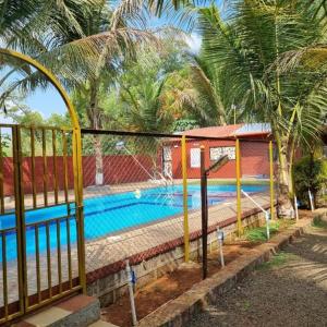 a swimming pool with a fence around it at NS Brothers Farm & Resort in Kolād
