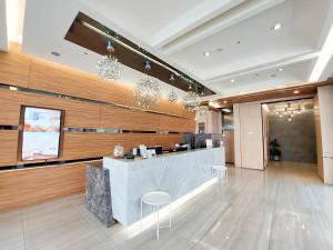 a hotel lobby with a reception counter and chandeliers at Green Hotel - Tea Way in Taichung