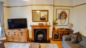 a living room with a fireplace and a tv at Gorgeous 4-Bed House in Bexhill-on-Sea sea views in Bexhill