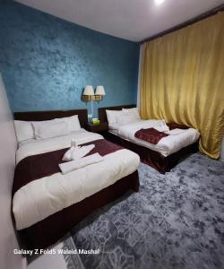 um quarto de hotel com duas camas com toalhas em Rabail House em Wadi Musa