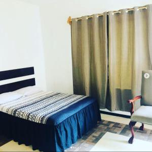 1 dormitorio con 1 cama, 1 silla y 1 ventana en Hotel Pedregal, en Tamasopo