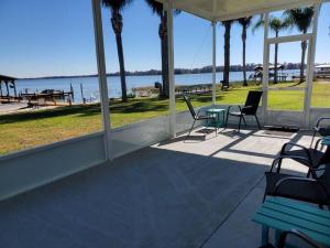 a porch with chairs and a table and a view of the water at Camp St. Cabanas Unit 3 on Lake Dora in Tavares