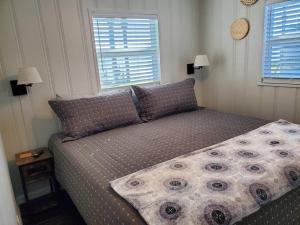 a bed in a small room with two windows at Camp St. Cabanas Unit 3 on Lake Dora in Tavares