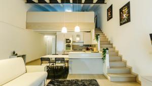 ein Wohnzimmer und eine Küche mit einer Treppe in einem Zimmer in der Unterkunft Palazzo Romeo in Verona