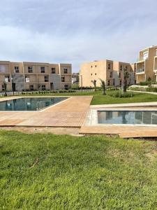 - une piscine au milieu d'une cour avec des bâtiments dans l'établissement Appartement with view on the sea and golf, à Taghazout