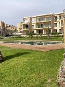 une piscine en face d'un grand bâtiment dans l'établissement Appartement with view on the sea and golf, à Taghazout