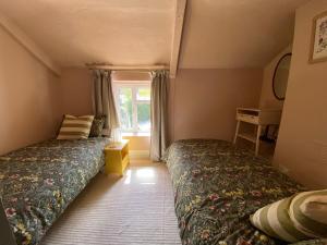 two beds in a small room with a window at Seaside Georgian gem in Combe Martin