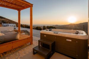 a hot tub on a patio with the sunset at Naxos Aethereal View in Kastraki Naxou