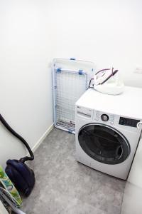 a washing machine sitting in a room with a vacuum at LA BATISSE l'arbre beige in Le Grand-Abergement