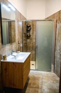 W łazience znajduje się umywalka oraz prysznic z lustrem. w obiekcie Residence Kalispera w mieście Scalea