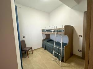 Residence Kalispera في سكاليا: غرفة صغيرة مع سرير بطابقين وكرسي