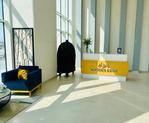 a lobby with a waiting area with a warner bros sign and a chair at Yas Island 1BR Apt with balcony near Sea World in Abu Dhabi
