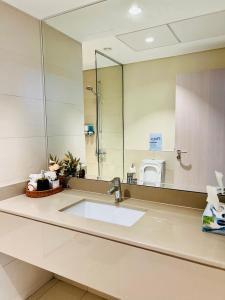 a bathroom with a sink and a large mirror at Yas Island 1BR Apt with balcony near Sea World in Abu Dhabi