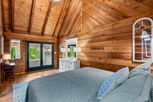 um quarto com paredes de madeira, uma cama e uma secretária em Lake Forest Lodge at Rough River em Fentress McMahan