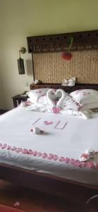 una cama con dos cisnes hechos de corazones en Lobo Wildlife Lodge, en Serengeti