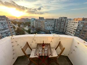 uma mesa e cadeiras numa varanda com vista para a cidade em Bird NEST 2 room apartment em Bucareste