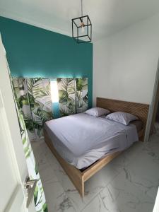 Bett in einem Schlafzimmer mit blauer Wand in der Unterkunft Villa du soleil in Les-Pennes-Mirabeau