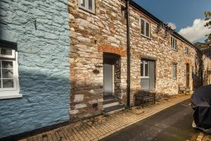 a brick building with a blue wall and a door at 1 Castle Mews in Dartmouth