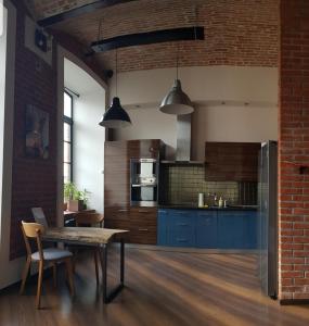 a kitchen with a table and a brick wall at Studio Mały Rynek in Żyrardów