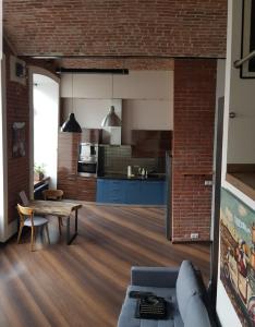 a living room and kitchen with a brick wall at Studio Mały Rynek in Żyrardów