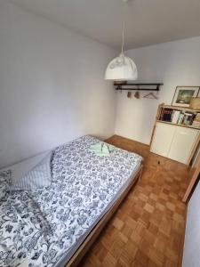 a bedroom with a bed with a blue and white comforter at Apartment Gulek in Zreče