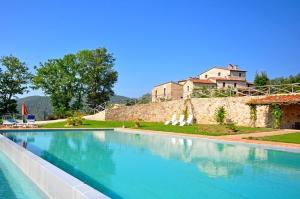 a large swimming pool with a castle in the background at Villa Vittorio by PosarelliVillas in Lama