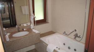 a bathroom with a sink and a bath tub at Vila Codrin Neptun-Olimp in Neptun