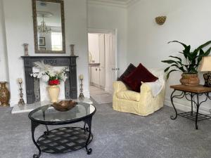 a living room with a chair and a table at Ashbourne Holiday Homes in Ashbourne