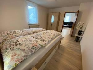 a bedroom with a bed with a floral bedspread at Vali‘s Apartment One in Dettingen an der Erms