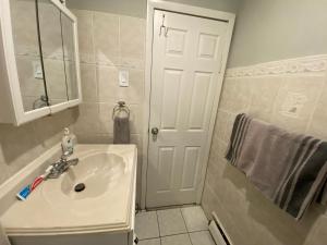 a white bathroom with a sink and a mirror at 1 COZY APt IN WEST NY, NEW JERSEY, at 2 bloks from bus stop-15 minutes 2NY 7MINUTES VIA NYWATERWAY FERRY-BETTER CAN'T BE!! in West New York