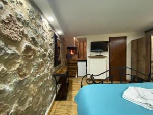 a room with a stone wall next to a bed at Alexandros Guesthouse in Arachova