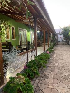 a green building with a patio with plants at CASA POR TEMPORADA NA SERRA in Ibiapina