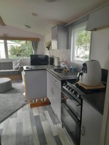 een keuken met een wastafel en een fornuis top oven bij Arnies Place Beacon Fell in Longridge