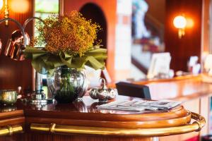 eine Vase Blumen auf einem Tisch in einem Restaurant in der Unterkunft Hotel am Schlosspark Zum Kurfürst in Oberschleißheim