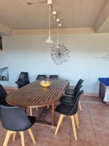 une salle à manger avec une table en bois et des chaises noires dans l'établissement casa del lago -villa carlos paz, à Villa Carlos Paz