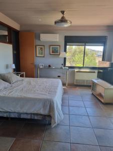 a bedroom with a bed and a large window at casa del lago -villa carlos paz in Villa Carlos Paz