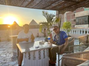 two people sitting at a table on a patio at King Badr Pyramids Inn in Cairo