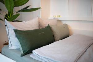 un sofá con varias almohadas y una planta en Zentral Smart Apartment, en Zwickau