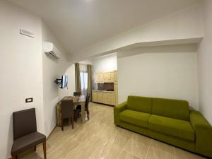 een woonkamer met een groene bank en een tafel bij Residence Kalispera in Scalea