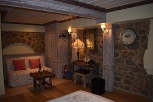 アラコバにあるAlexandros Guesthouseのベッドルーム1室(ベッド1台、壁に時計付きのテーブル付)