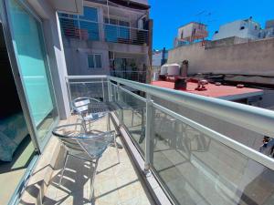 a balcony with a chair and a table on a building at Roosevelt 1681 in Buenos Aires