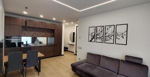 a living room and kitchen with a couch and a table at Birštono Perlas apartamentai in Birštonas