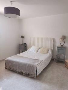 1 dormitorio con 1 cama con 2 mesas y 1 lámpara en Rez de villa pour 4 personnes, en Trets