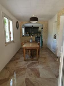 cocina con mesa de madera en una habitación en Rez de villa pour 4 personnes, en Trets