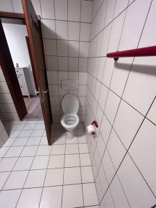 La salle de bains est pourvue de toilettes et d'un rouleau de papier toilette. dans l'établissement Business Apartment Bühl, à Buhl