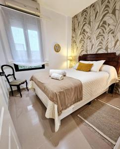 a bedroom with a bed and a chair and a window at Apartamento Vetalegua Jerez in Jerez de la Frontera