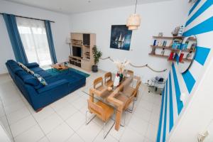 a living room with a blue couch and a table at Duplex moderne avec vue exceptionnelle sur la mer in Pointe-Noire